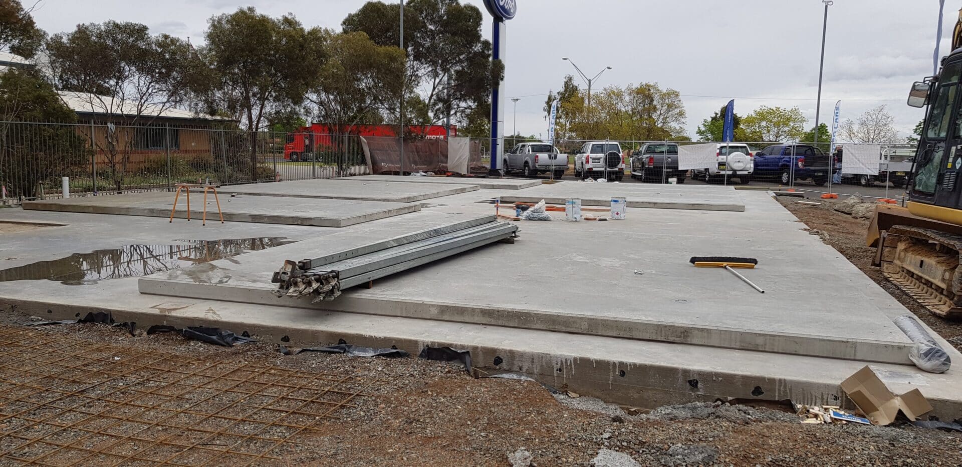 A concrete slab with some metal pipes laying on it